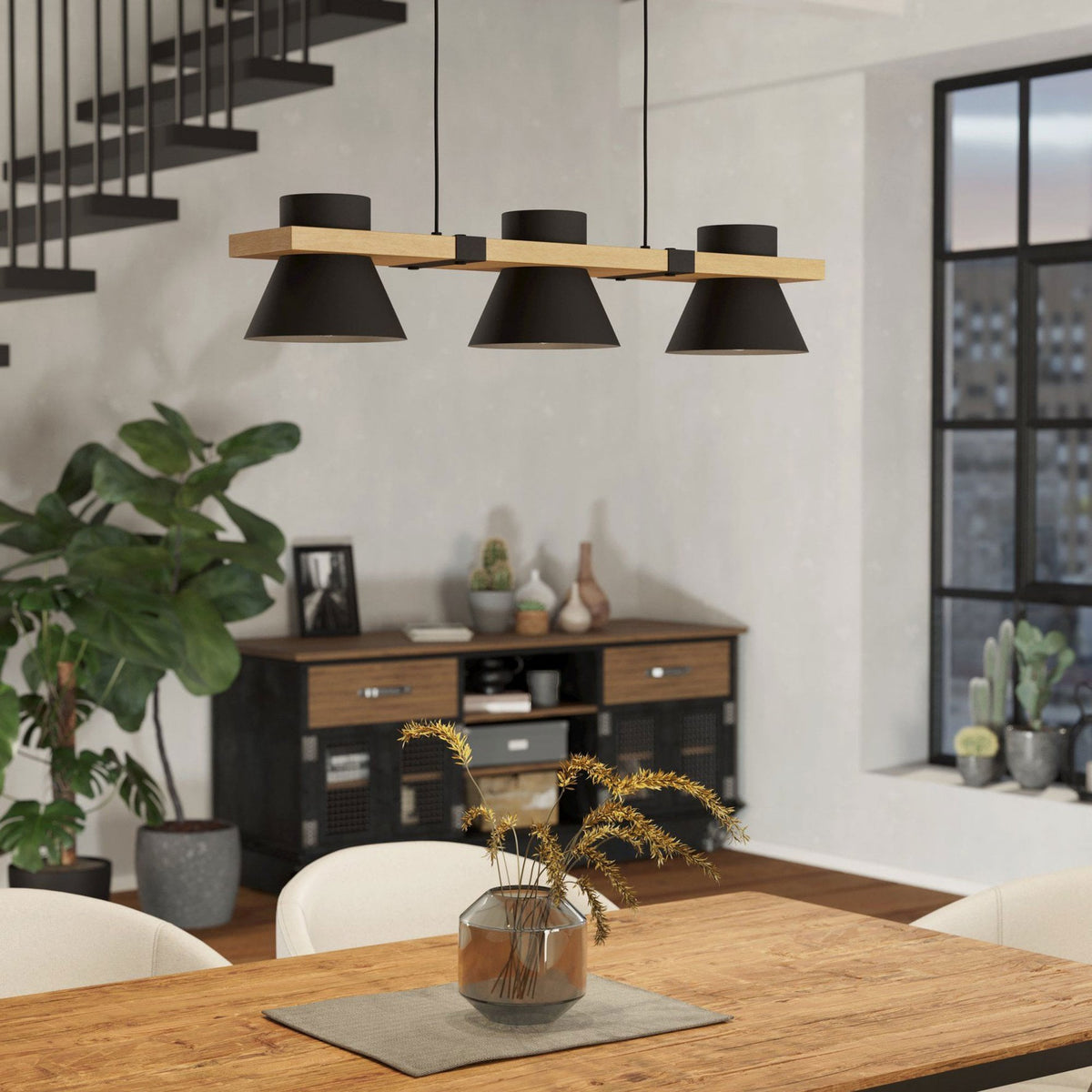 A black and wood pendant light hangs above a wooden dining table in a modern room.