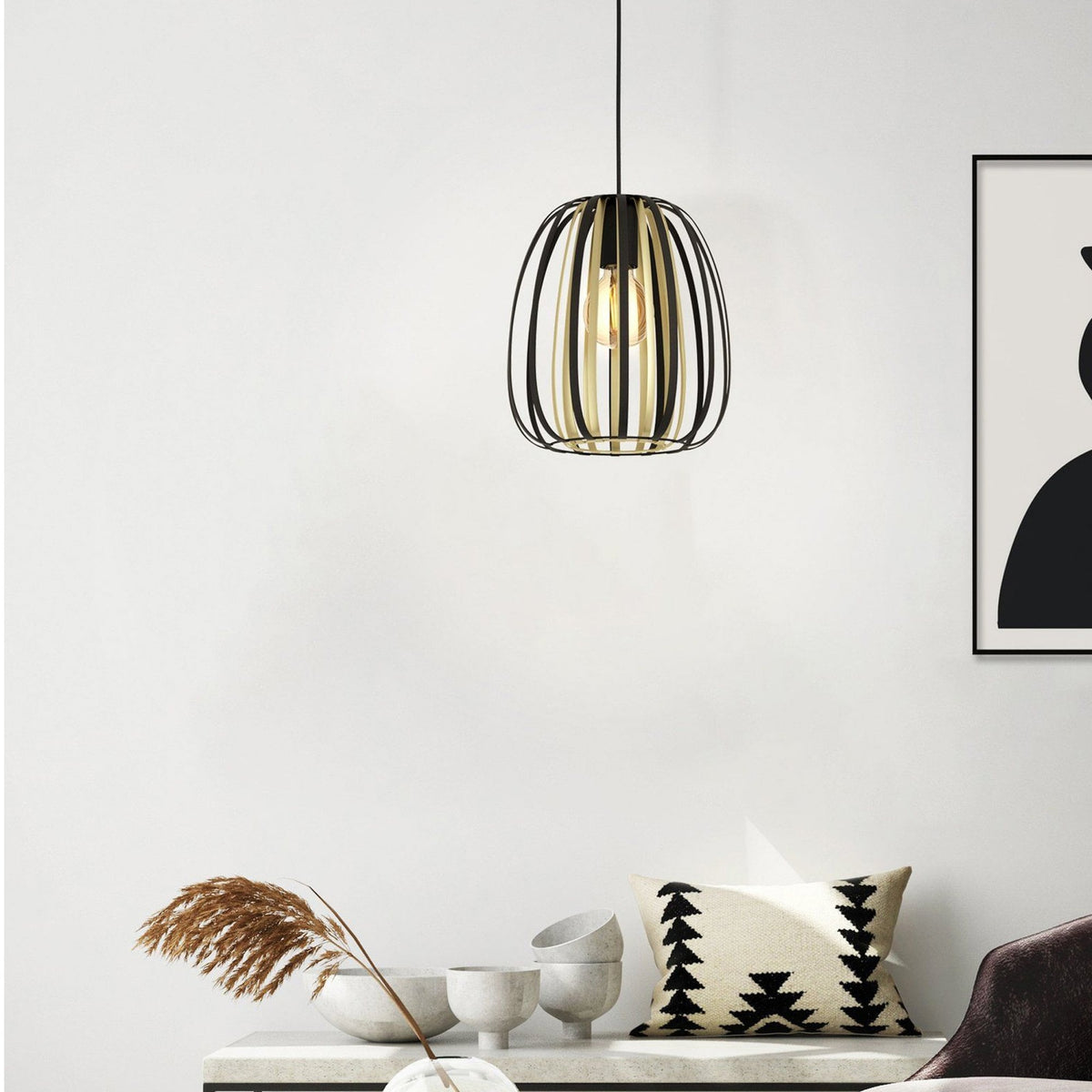 A black and gold pendant light illuminates a modern living room.