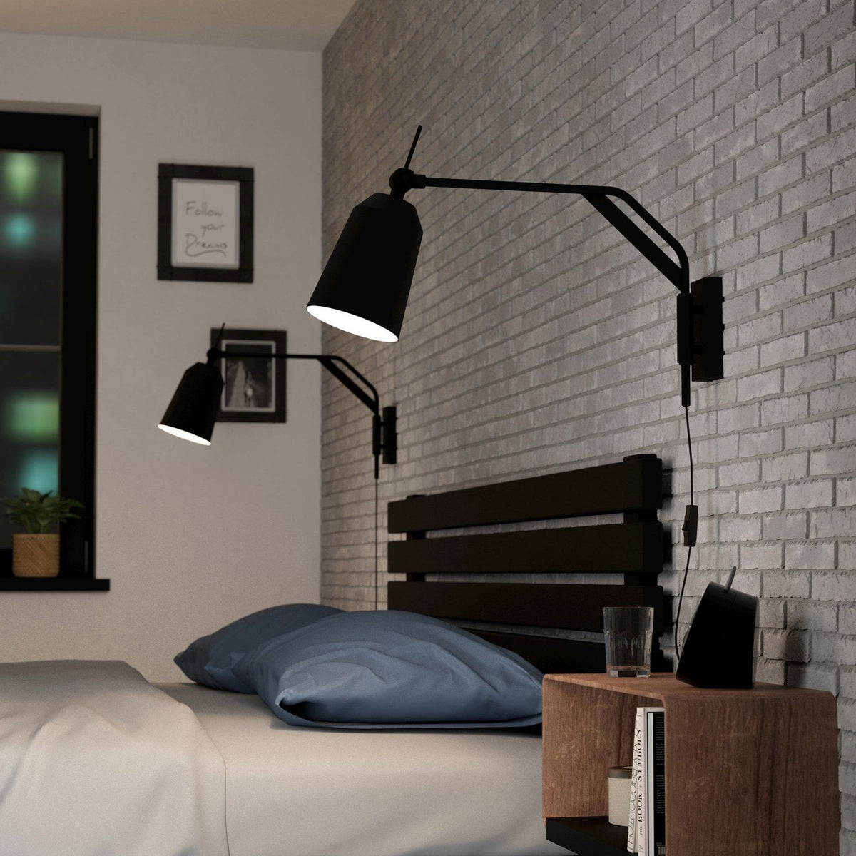 Two black adjustable wall lamps provide bedside lighting in a bedroom with grey brick walls.