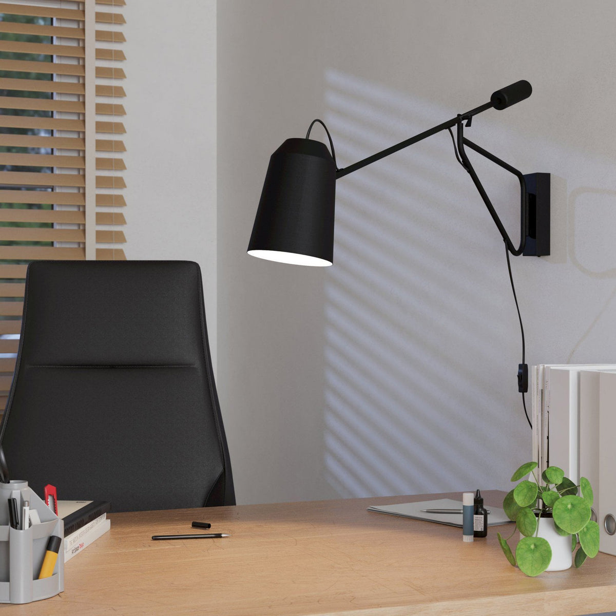 A black wall lamp with an adjustable arm over a desk, providing focused light.