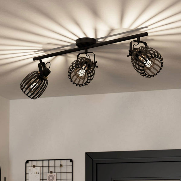A black three-spot track light casting ribbed shadows on a white ceiling above a doorway.