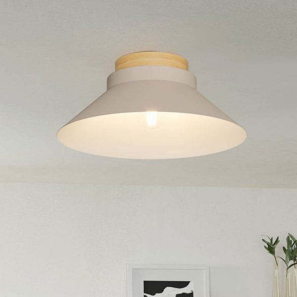 A modern beige flush mount light with a wooden top and exposed bulb on a white ceiling.