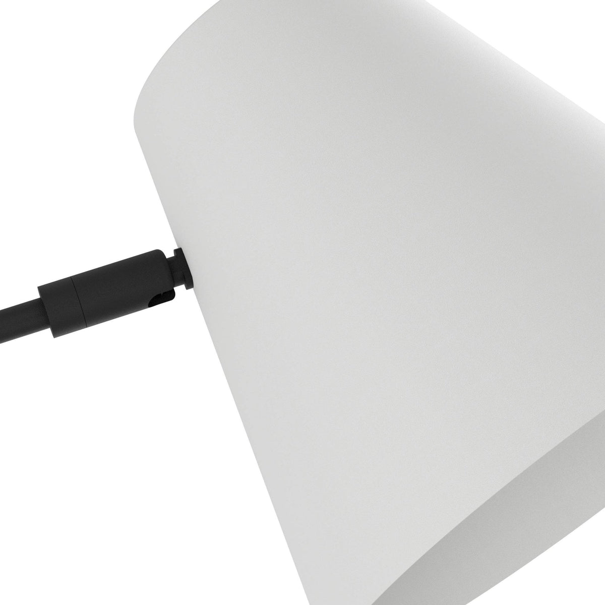 Close-up of the white cone shade and black arm joint of the wall light.