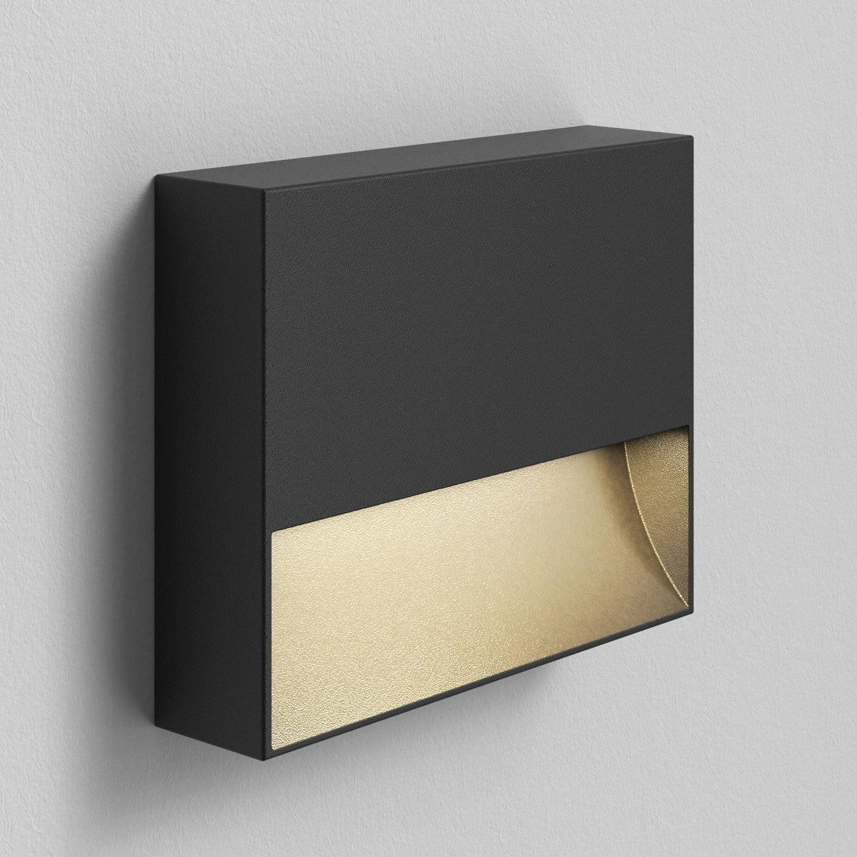 Black rectangular wall light with a gold interior, casting light downwards
