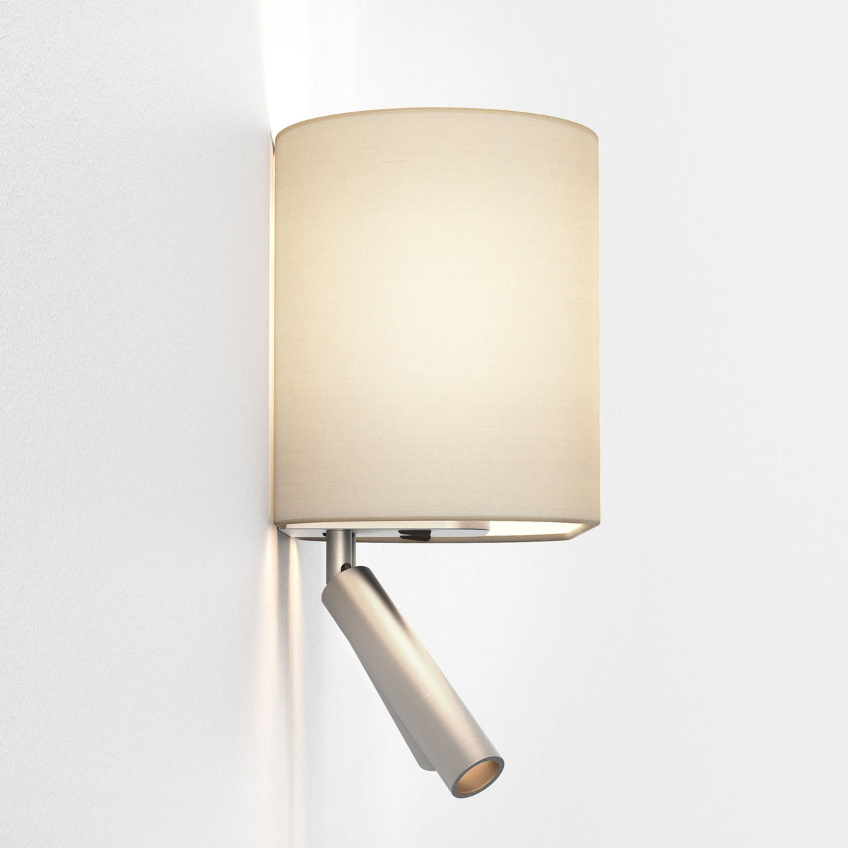 Wall mounted lamp with a cylindrical fabric shade and an adjustable metal spotlight below