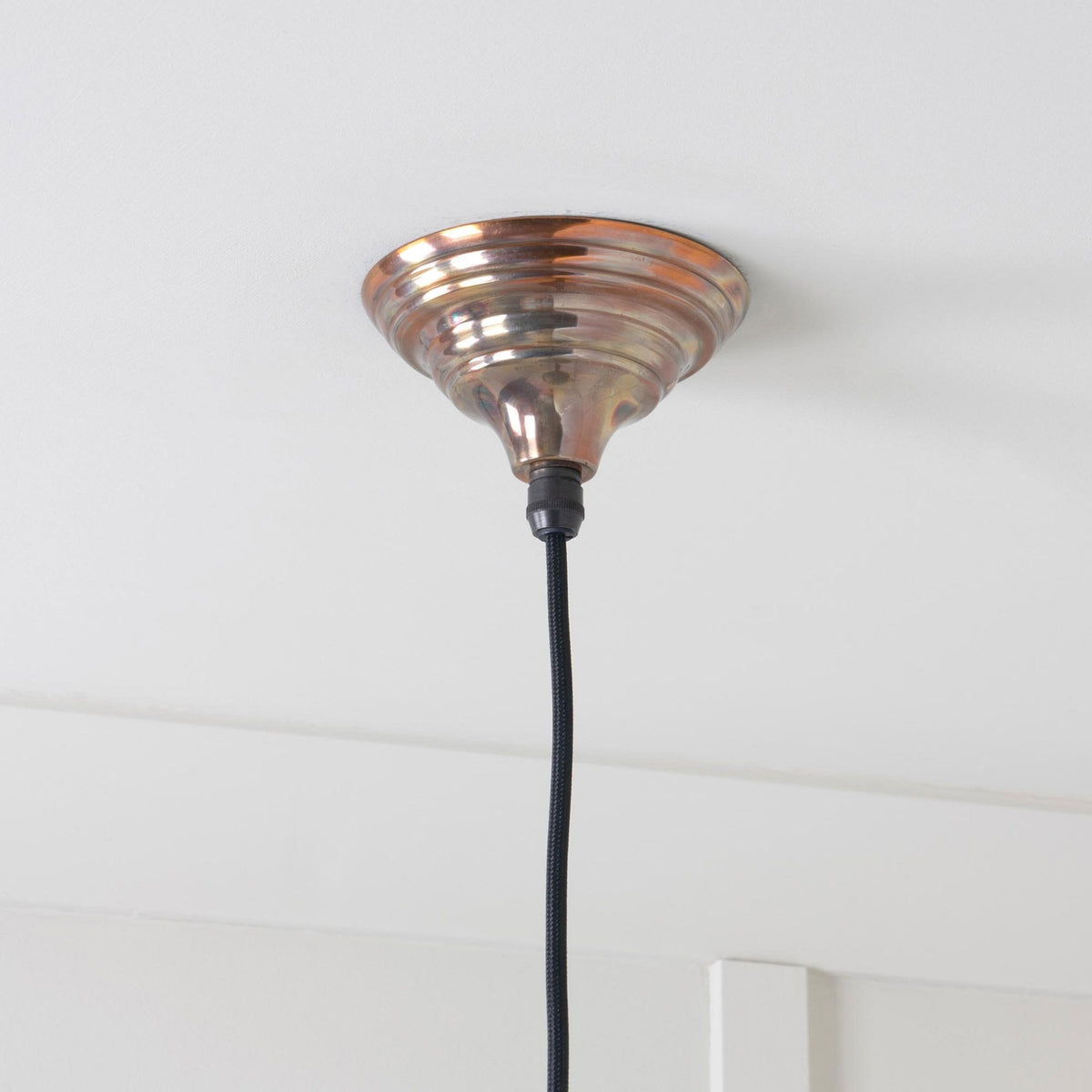 Close-up of the ceiling rose and black cable for the dome pendant light.