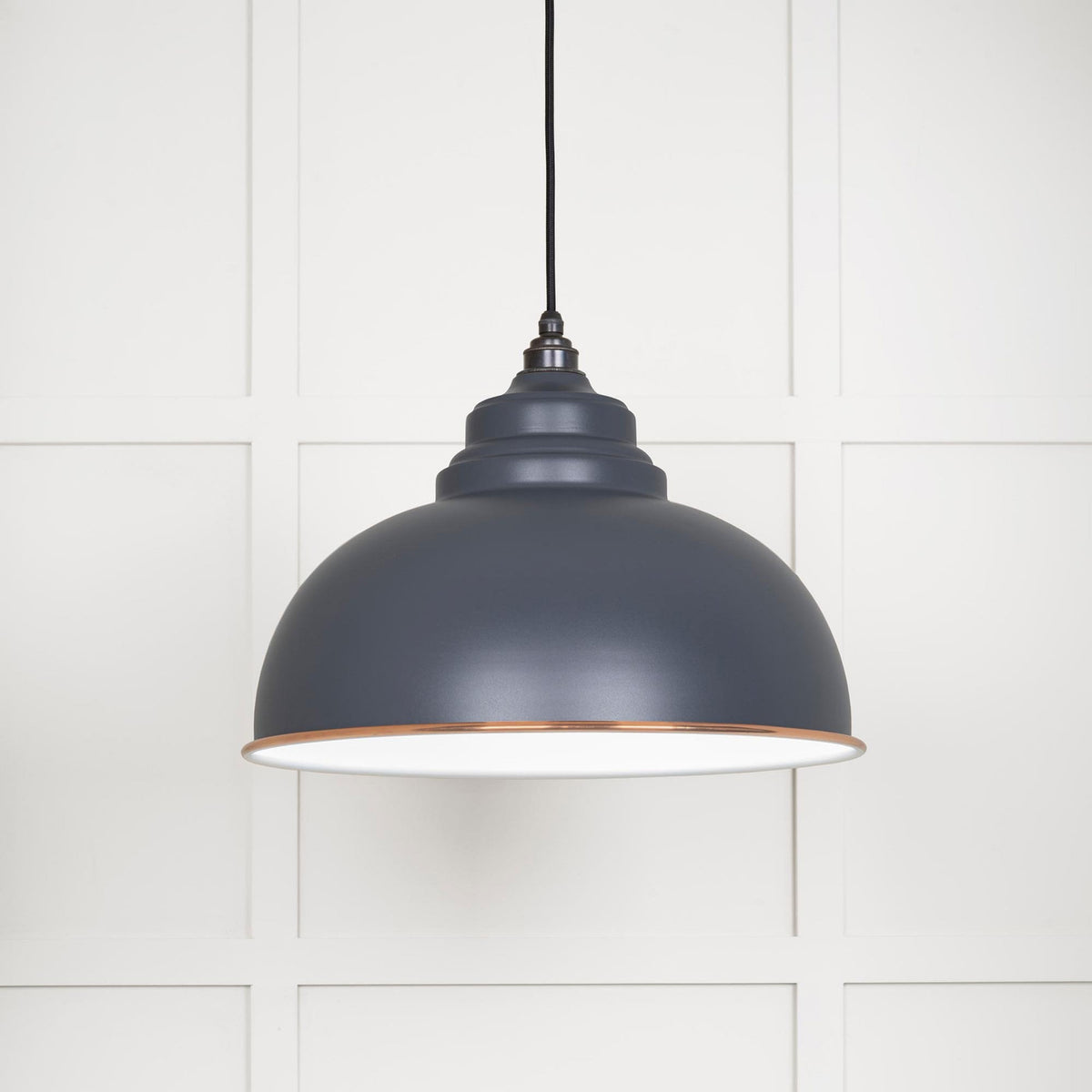 A close up of the Oxford pendant light against a white panelled wall.