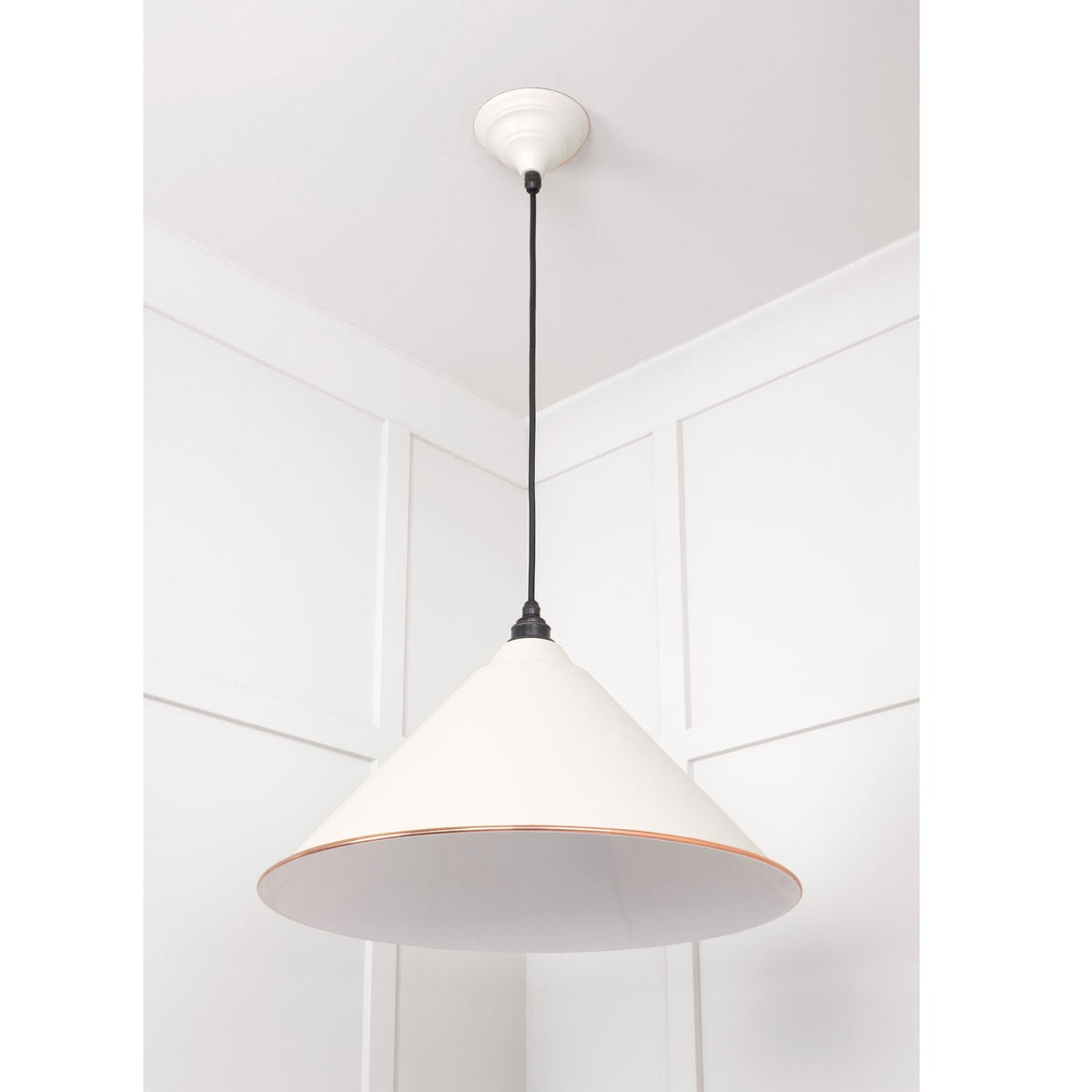 A white conical pendant light with a copper band hanging from a white ceiling.