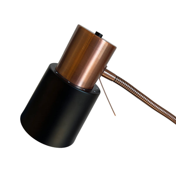 A close-up of the lamp's head, showing the antique brass and black finish.