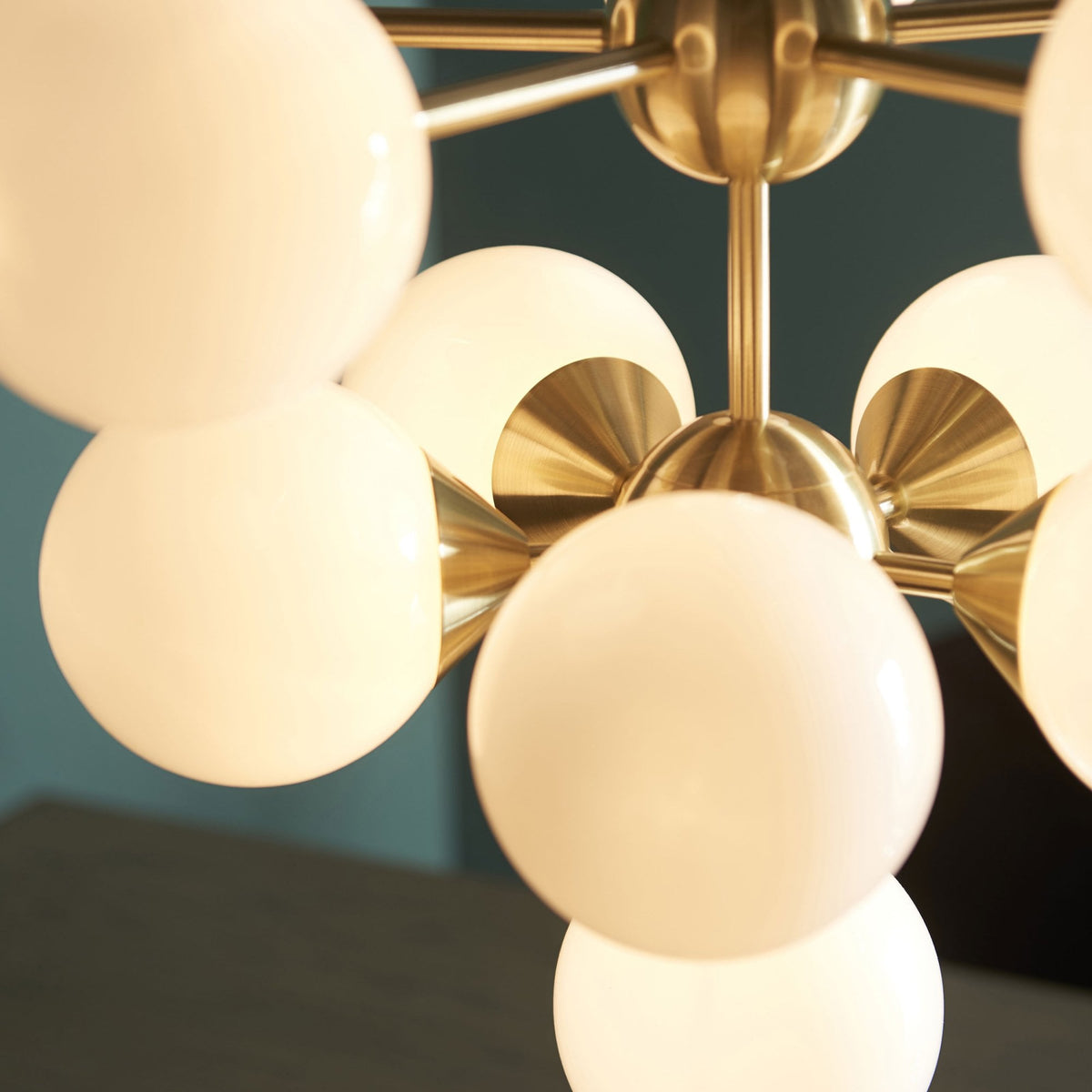 Close-up of a brass chandelier with white globe lights.