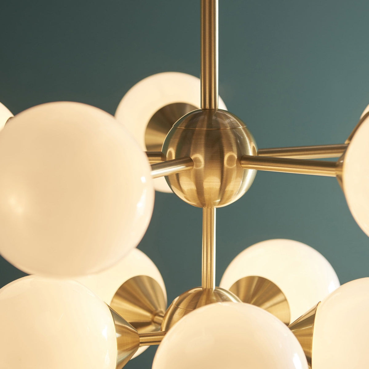 Close-up of the brass fixture and white globe lights of a chandelier.