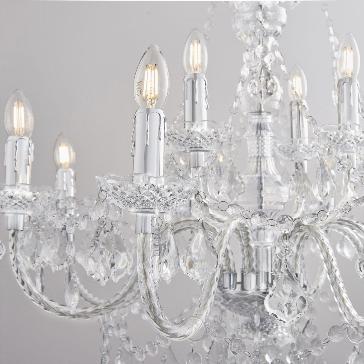 Close-up of a crystal chandelier with multiple lit candle-style bulbs and draped crystal strands.