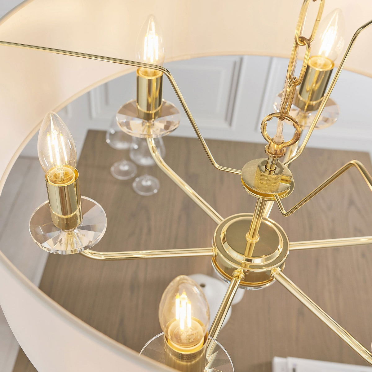 Overhead view of the chandelier showing the gold frame, crystal details, and exposed bulbs.