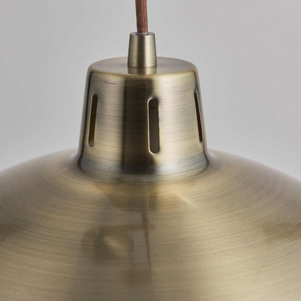 Close-up of the top of the brass dome shade, showing ventilation slots.