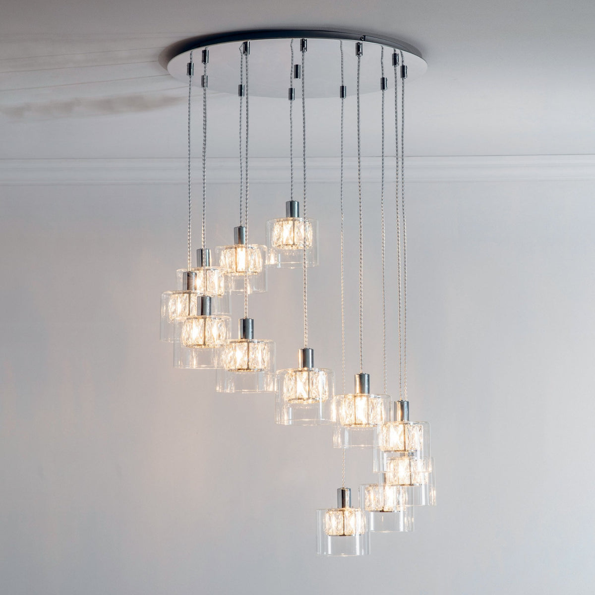 A modern chandelier with 12 lights in a spiral design, featuring clear glass shades and polished chrome accents.