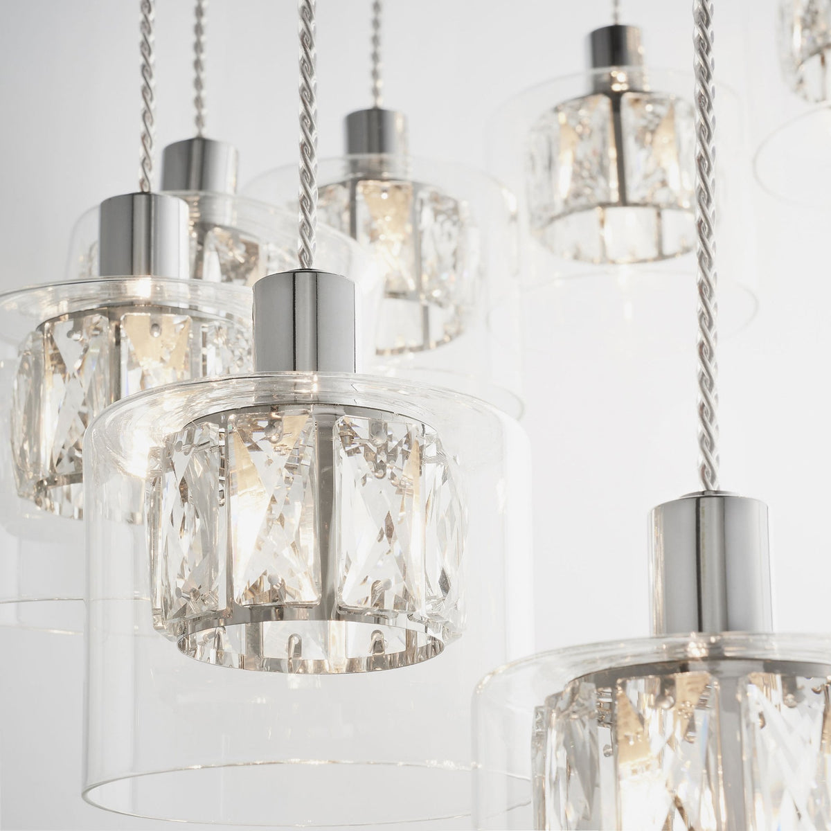 Close-up of multiple chandelier lights with clear glass shades and sparkling crystal details.