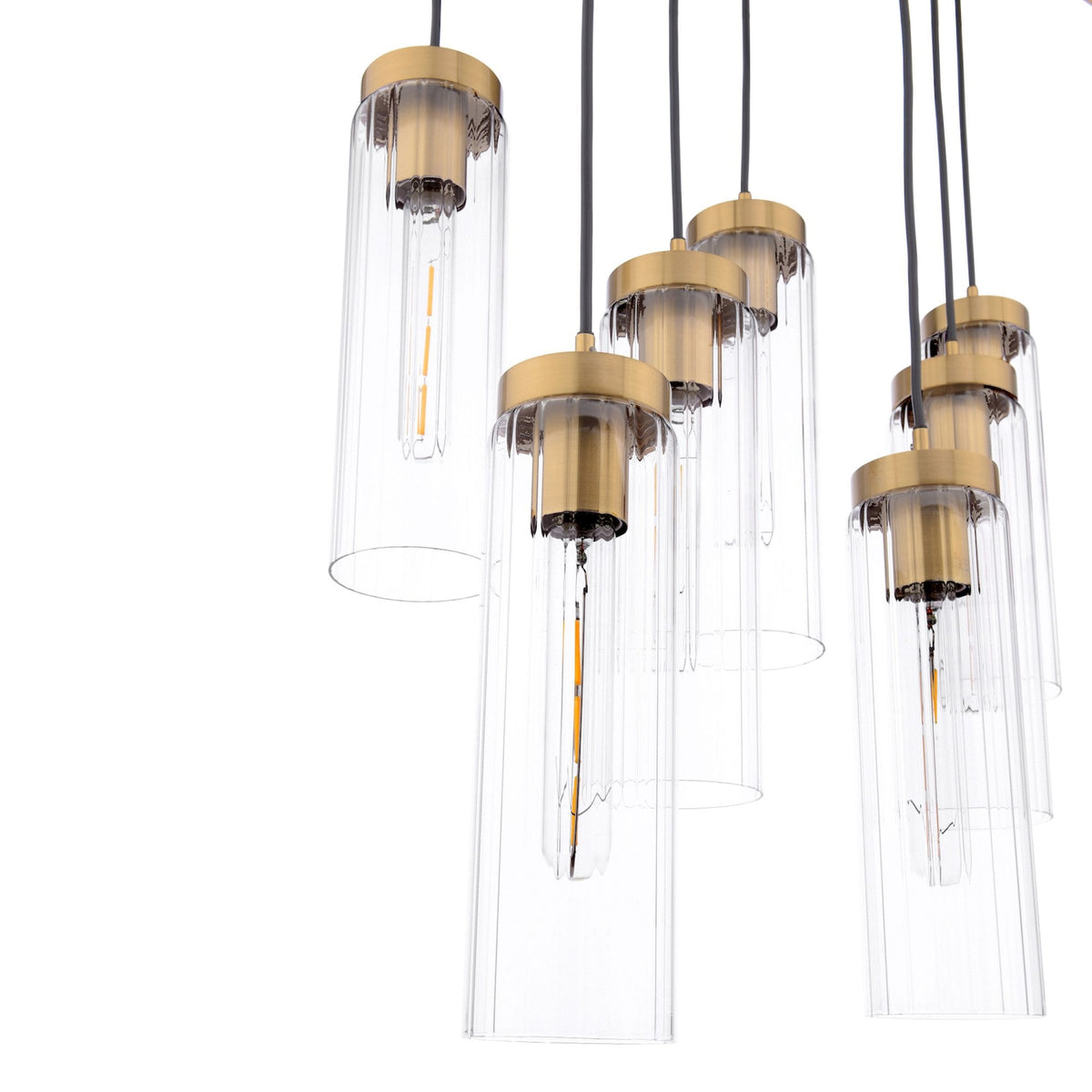 Modern chandelier with multiple clear glass cylinders and brass accents, hanging from black cords.