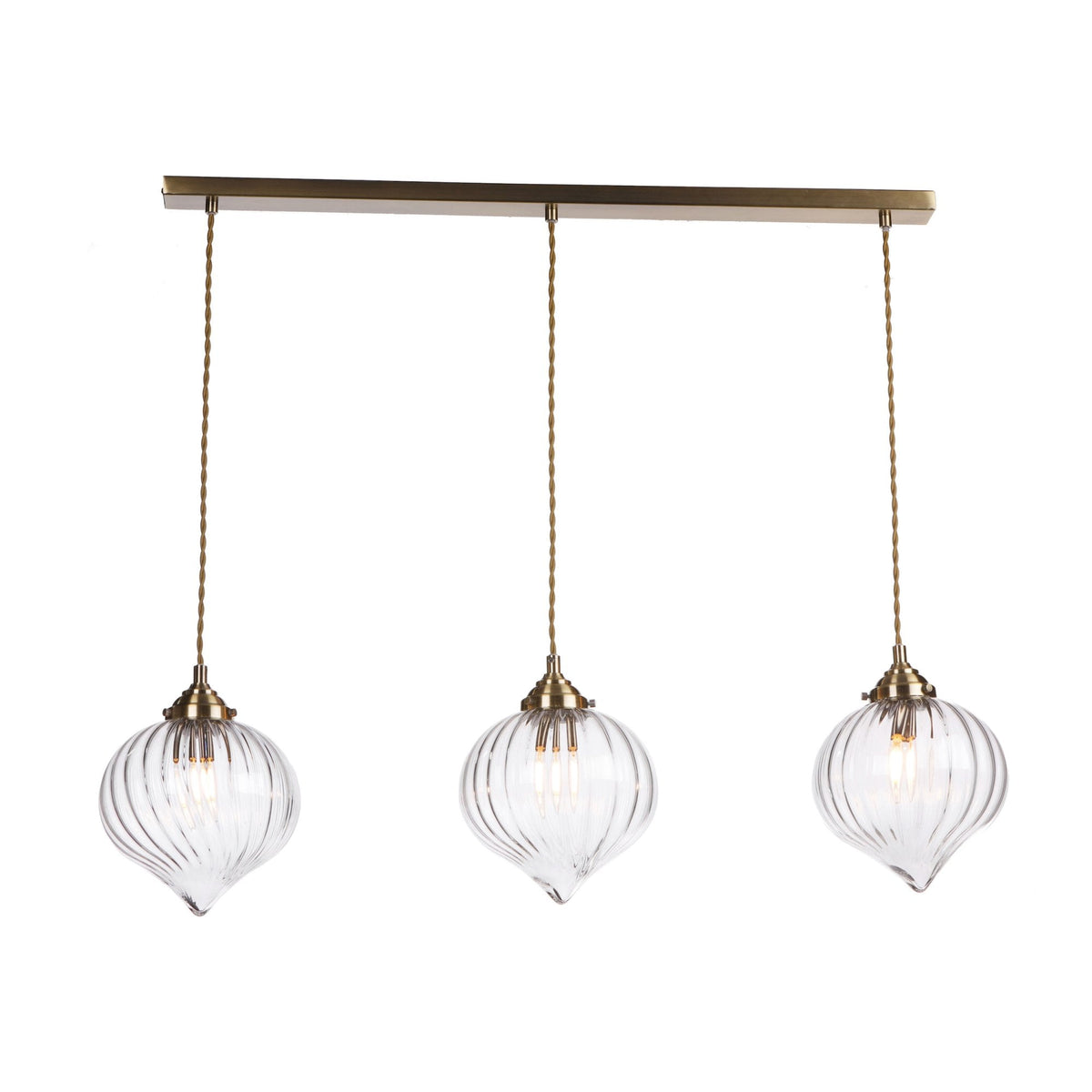 Three clear glass pendant lights with ribbed, onion-shaped shades hang from a brass bar.