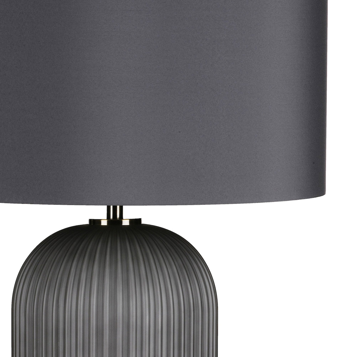 Close-up of a dark gray table lamp with a ribbed base and a smooth cylindrical shade.