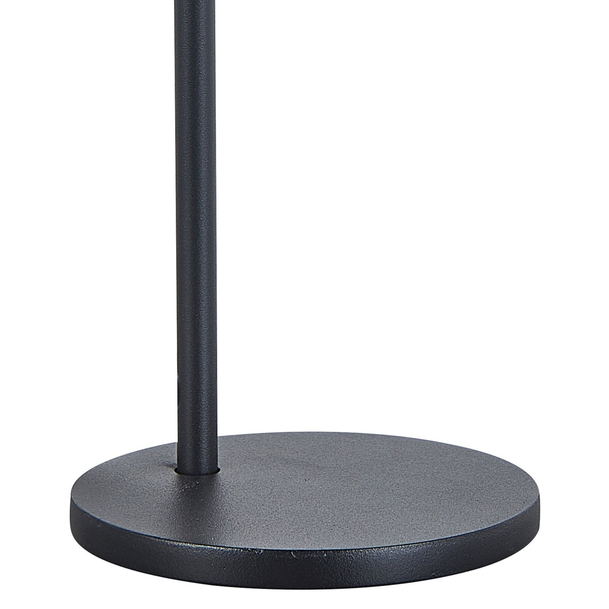 The round base of a black minimalist floor lamp on a white background.