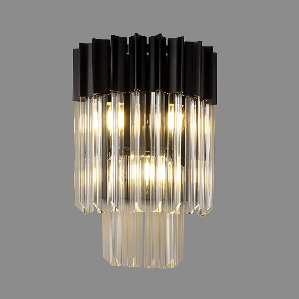 A modern black and clear glass wall light with the lights on, against a grey background.