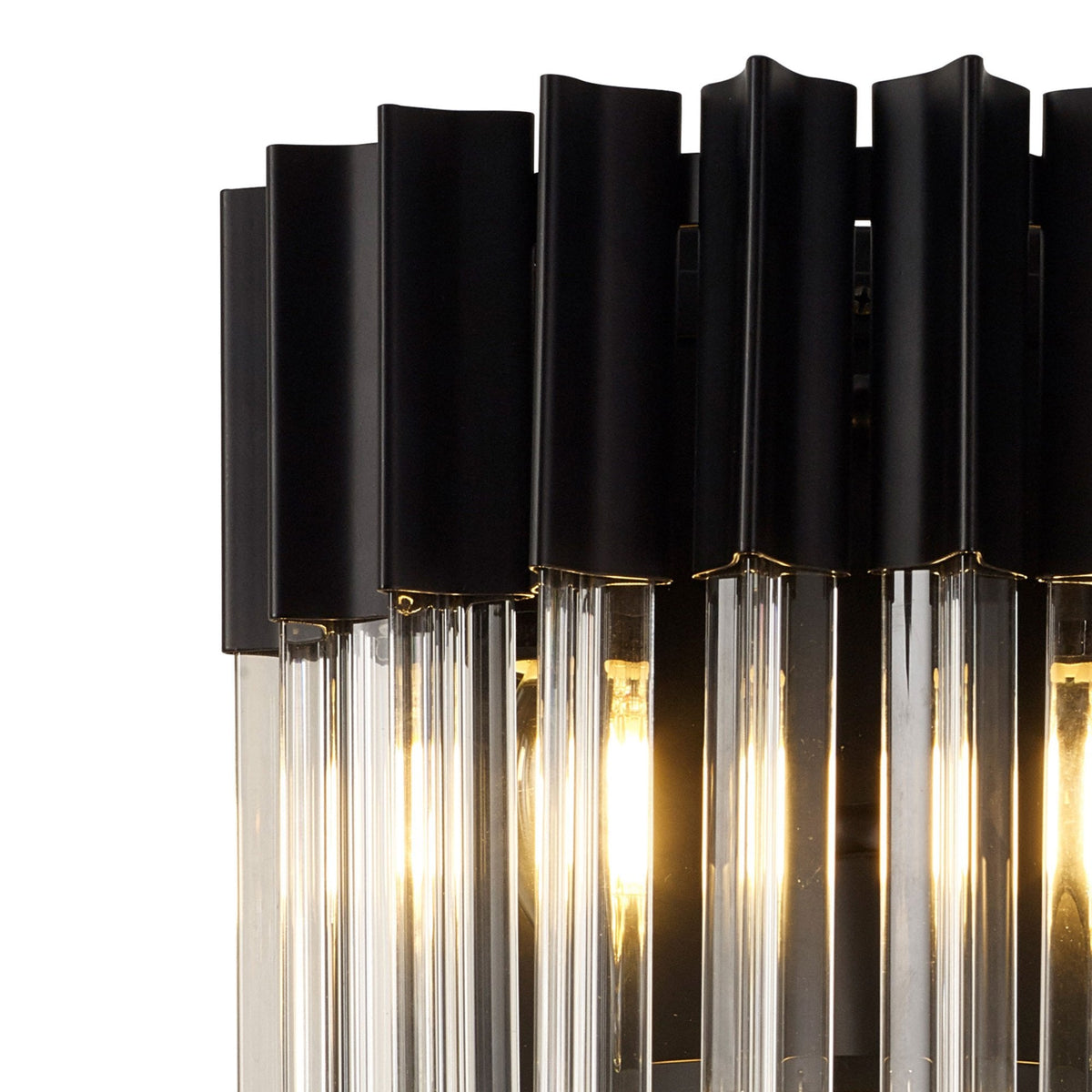 Close-up of the top section of the black and clear glass wall light with lights on.