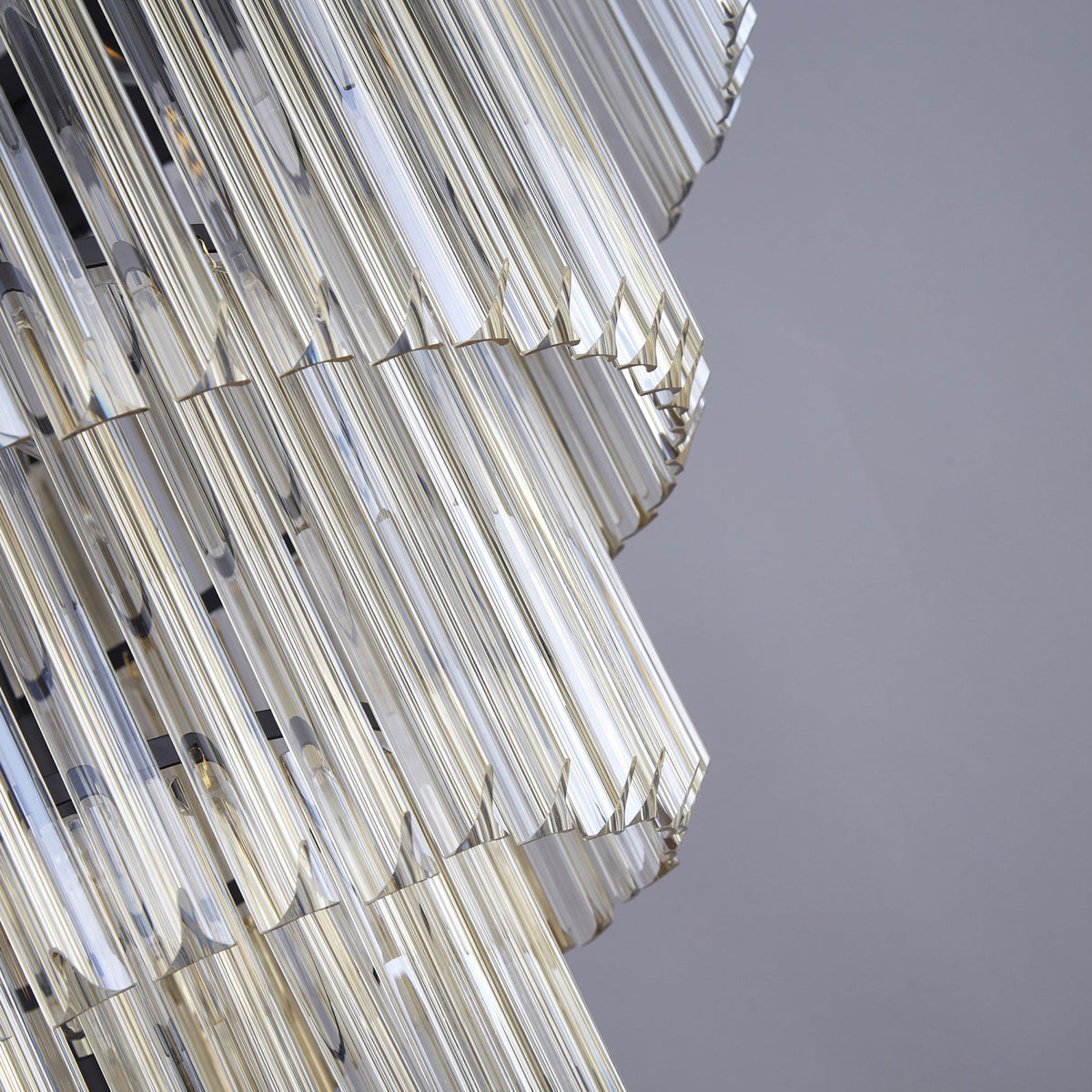 Close-up of the lower tiers of a crystal chandelier, showcasing the clear fluted glass rods.