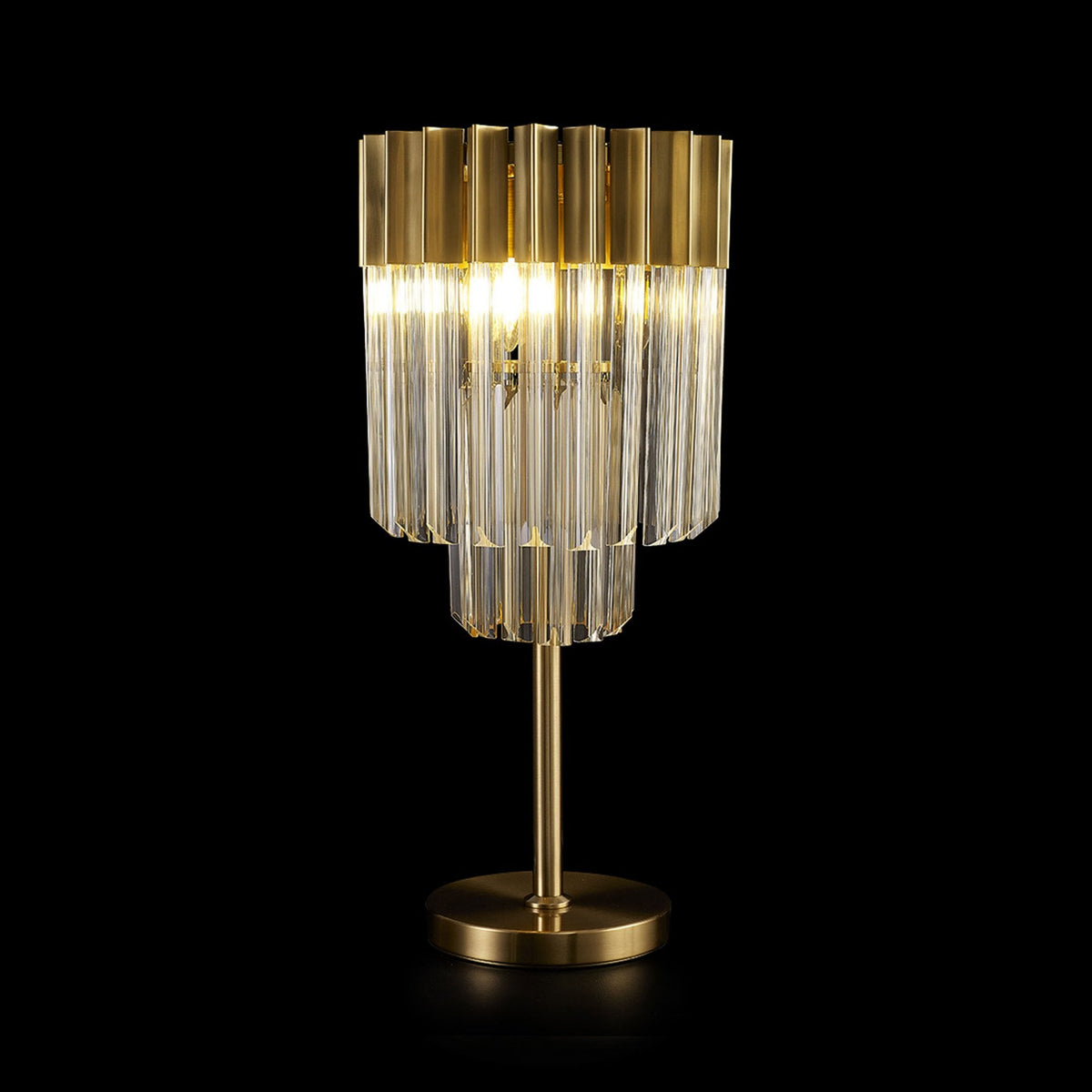 A modern brass table lamp with illuminated glass rods on a dark background.