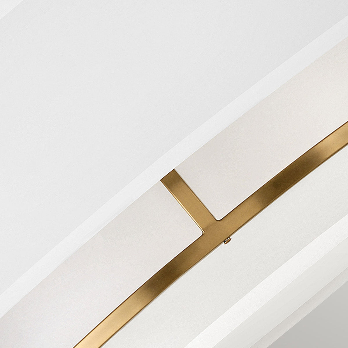 An upward-angled close-up of the brass frame supporting the layered white fabric shade.