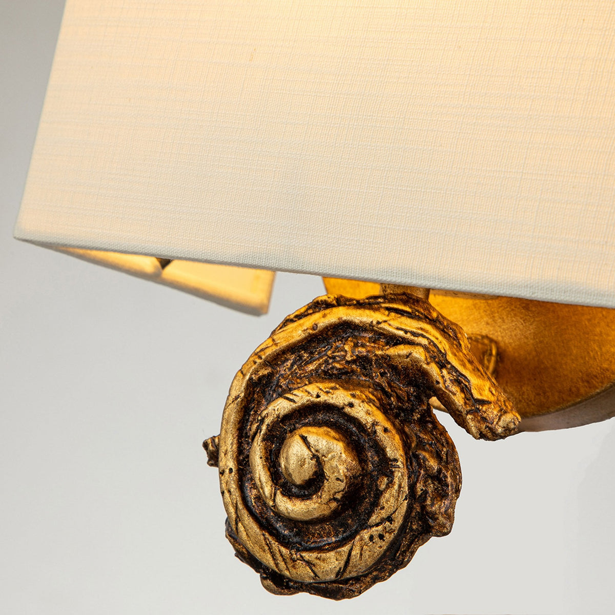 Swirl Small Wall Light in an Antiqued Gold Leaf Finish with Linen Shade