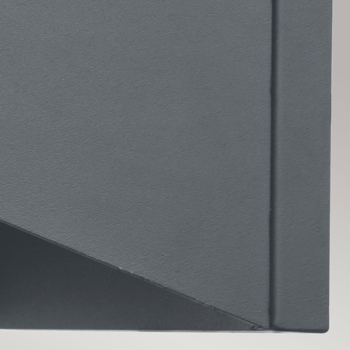 A close up of the modern curved grey wall light's metal fitting.
