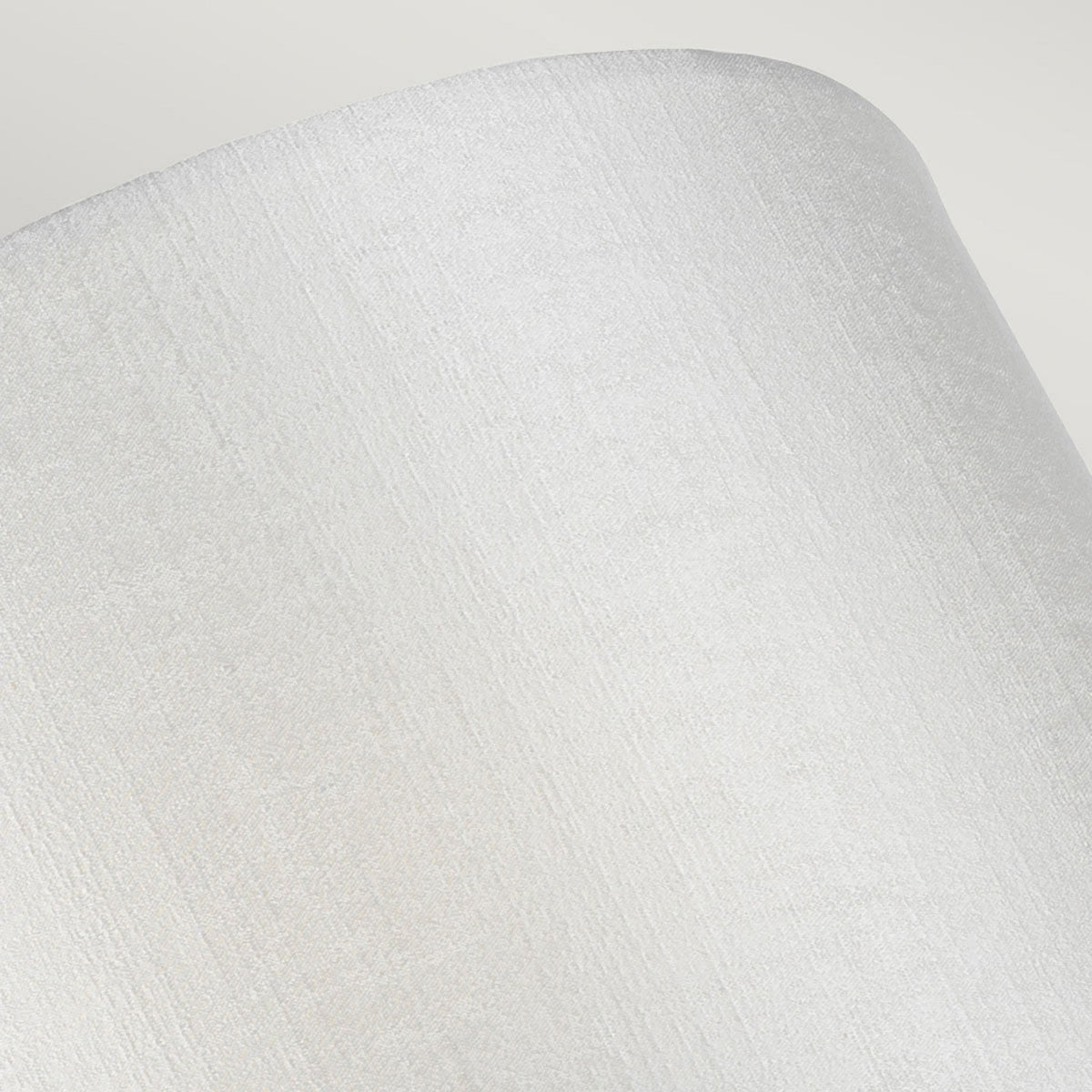 Close-up of the subtle texture of the white fabric shade on a modern wall light.