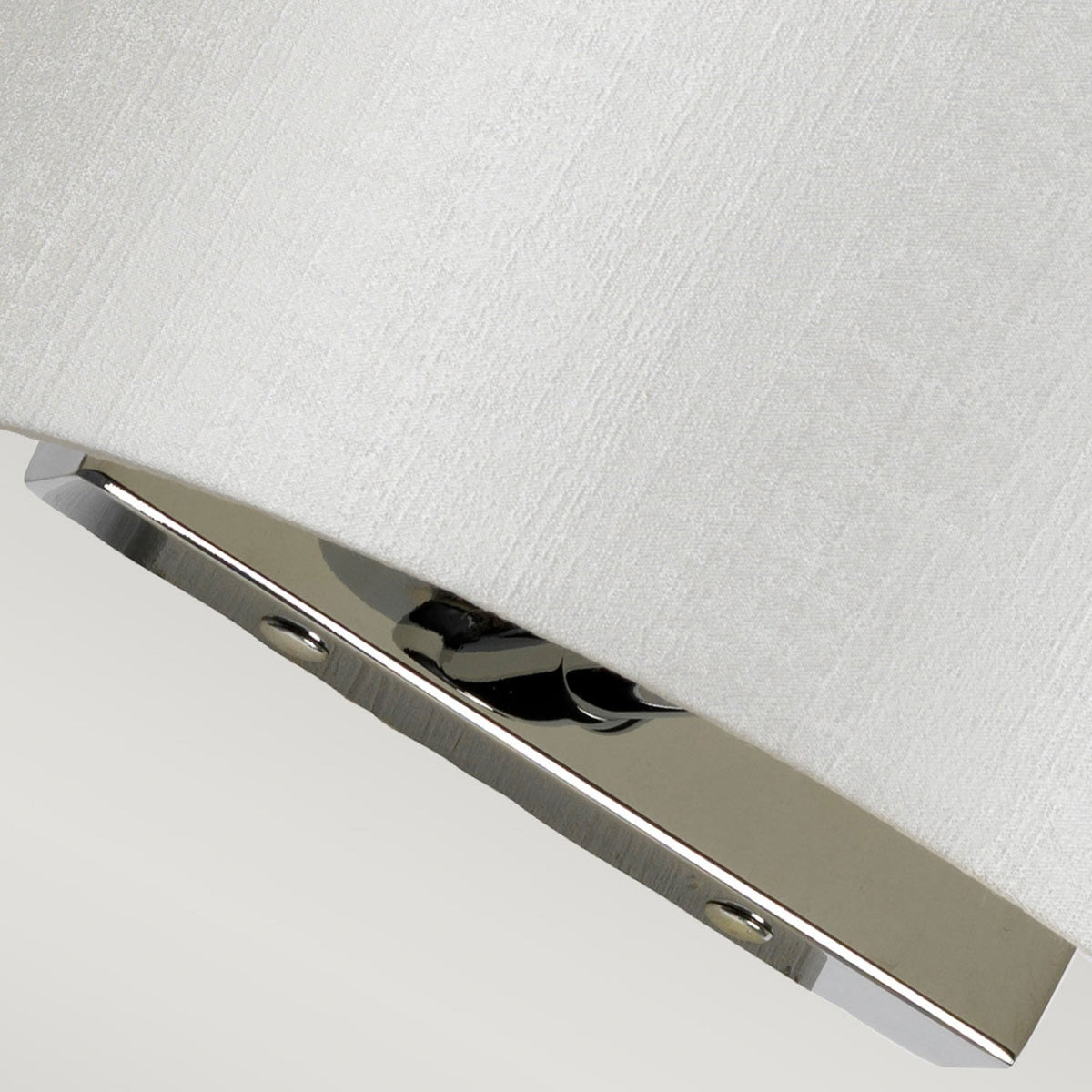 Angled view highlighting the smooth polished chrome base of a contemporary wall light.