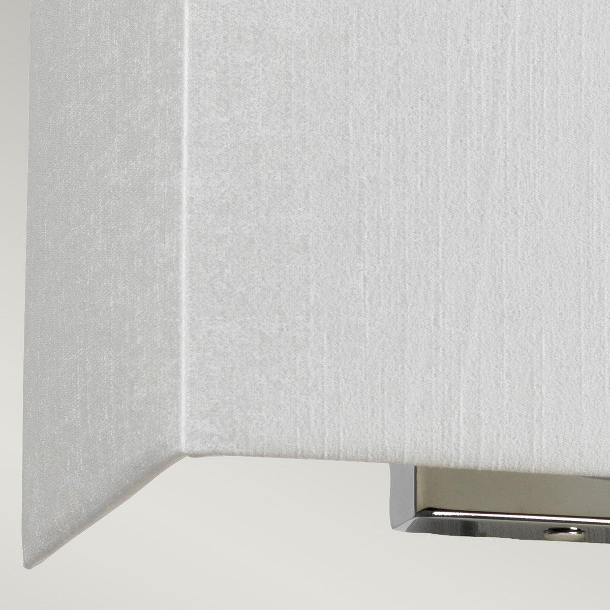 Close-up of the textured white fabric shade of a modern wall light.