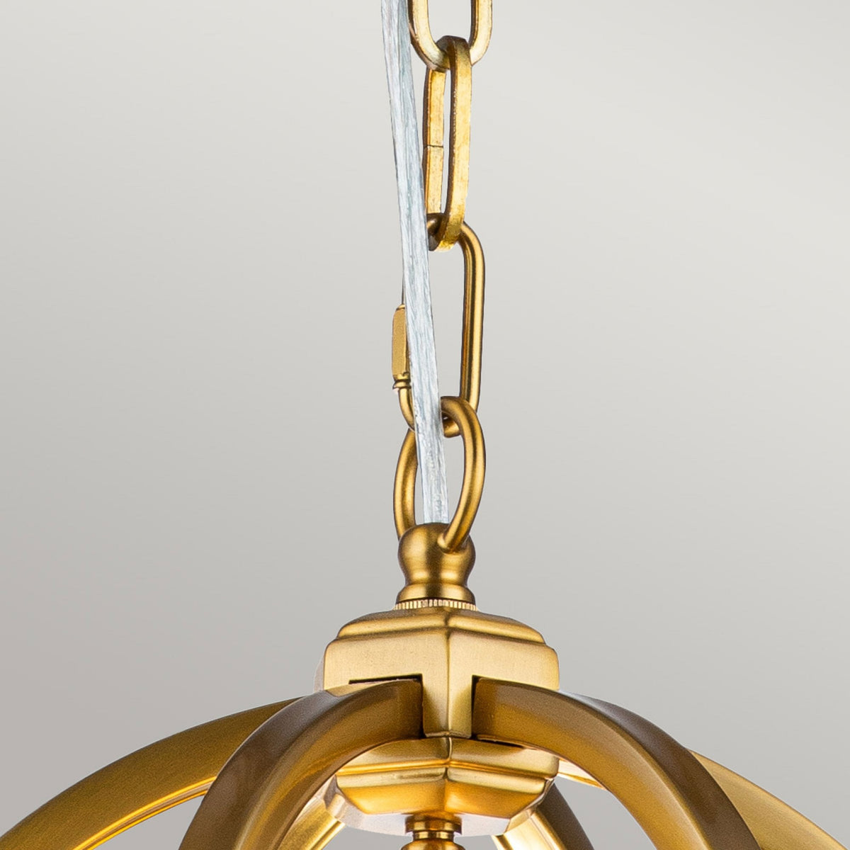 Close-up of the golden chain connecting the light to the ceiling rose.