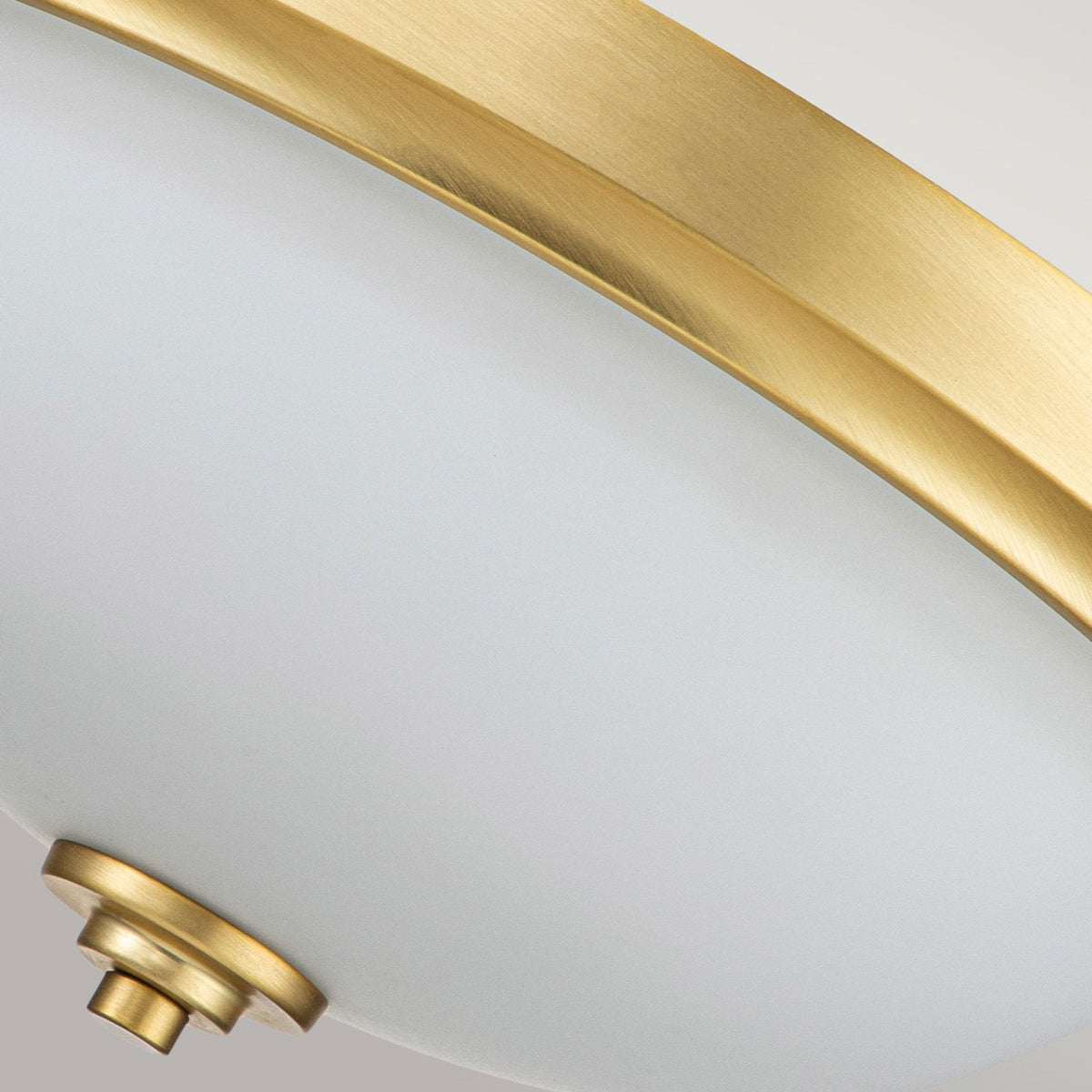 An upward angle showing the antique brass detailing and white glass of the Capulet flush mount light.