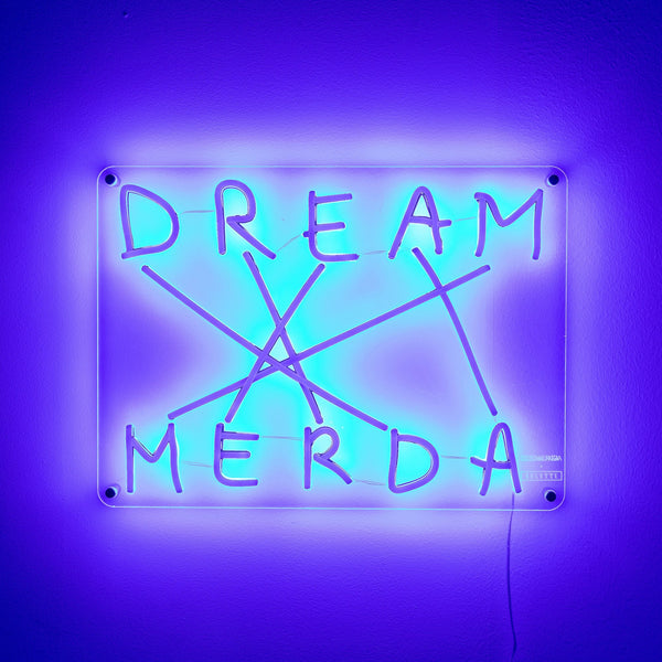 Glowing blue neon sign reads 'DREAM MERDA' with connecting lines, against purple wall.