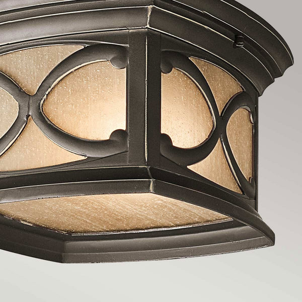 A close-up of the base of the bronze flush mount outdoor light.