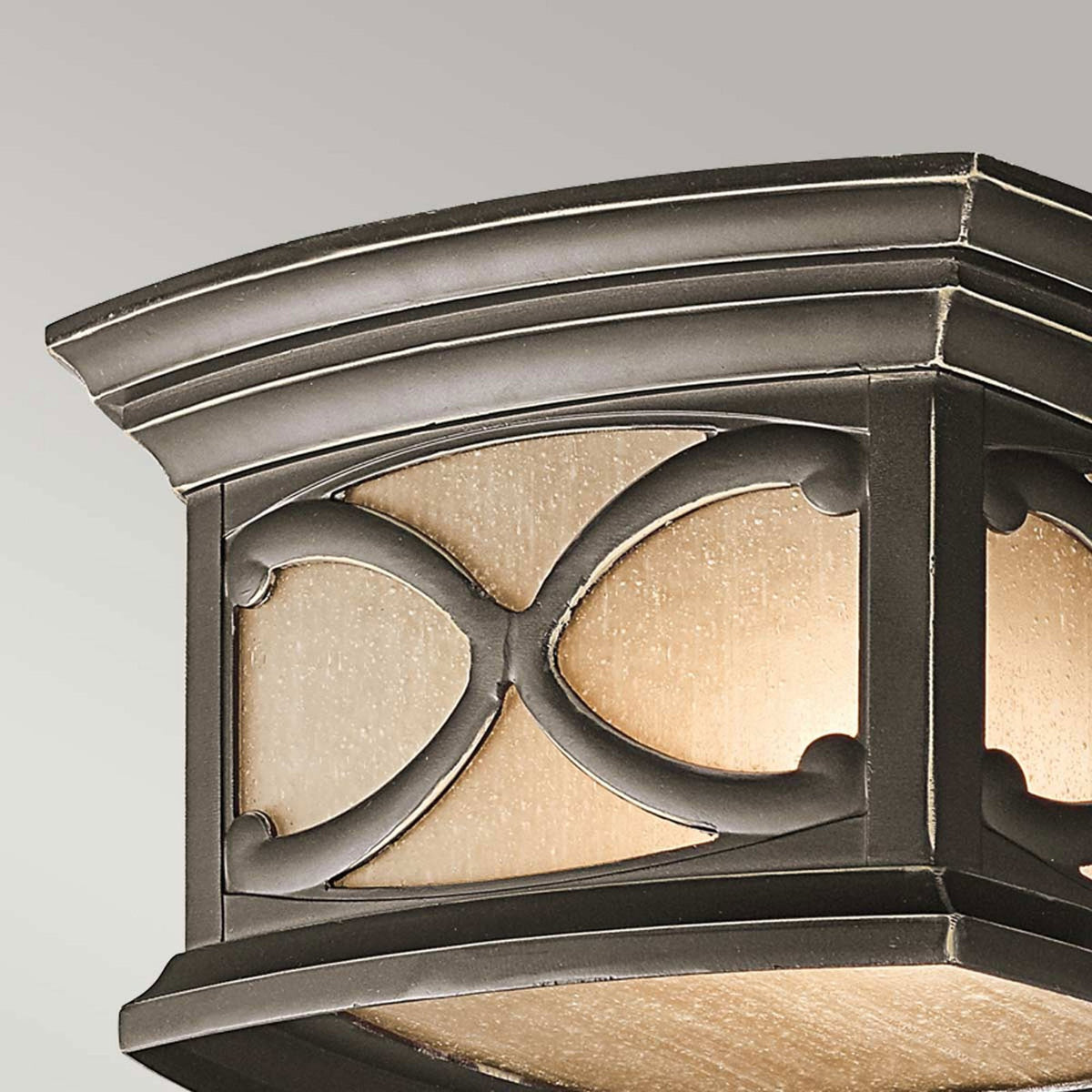 A close-up of the top part of the bronze flush mount outdoor light.