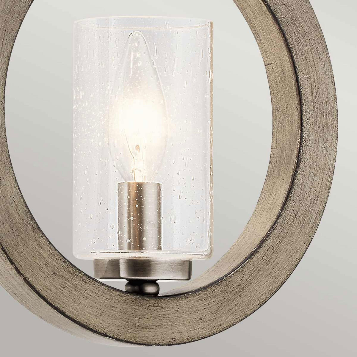 A detailed shot of the seeded glass shade and light bulb within the wood ring.