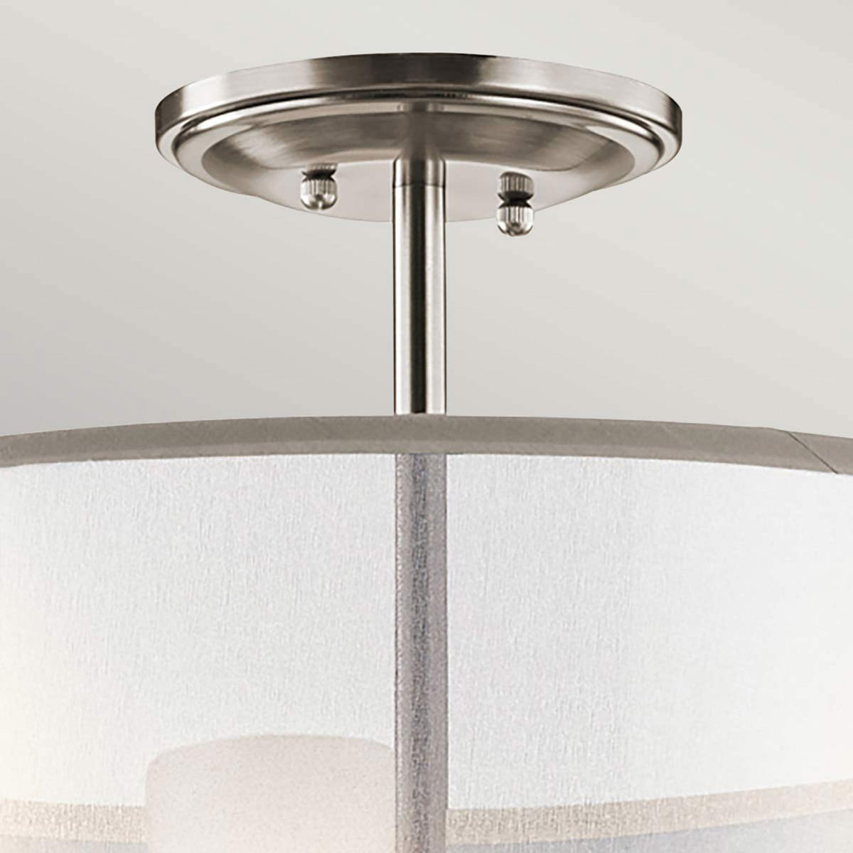 Close-up of the brushed nickel ceiling canopy and supporting rod of the light fixture.