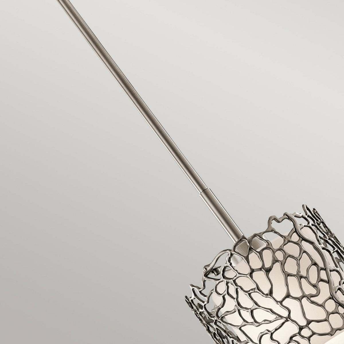 An upward-angled view of the pendant light's suspension rod, leading to the decorative shade.