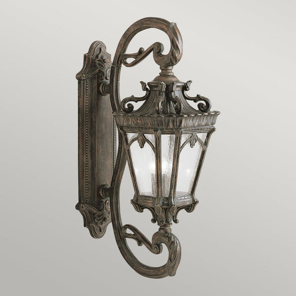 An antique bronze outdoor wall light with clear seeded glass.