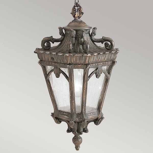 An antique bronze outdoor hanging lantern with textured glass panels, providing ambient lighting.