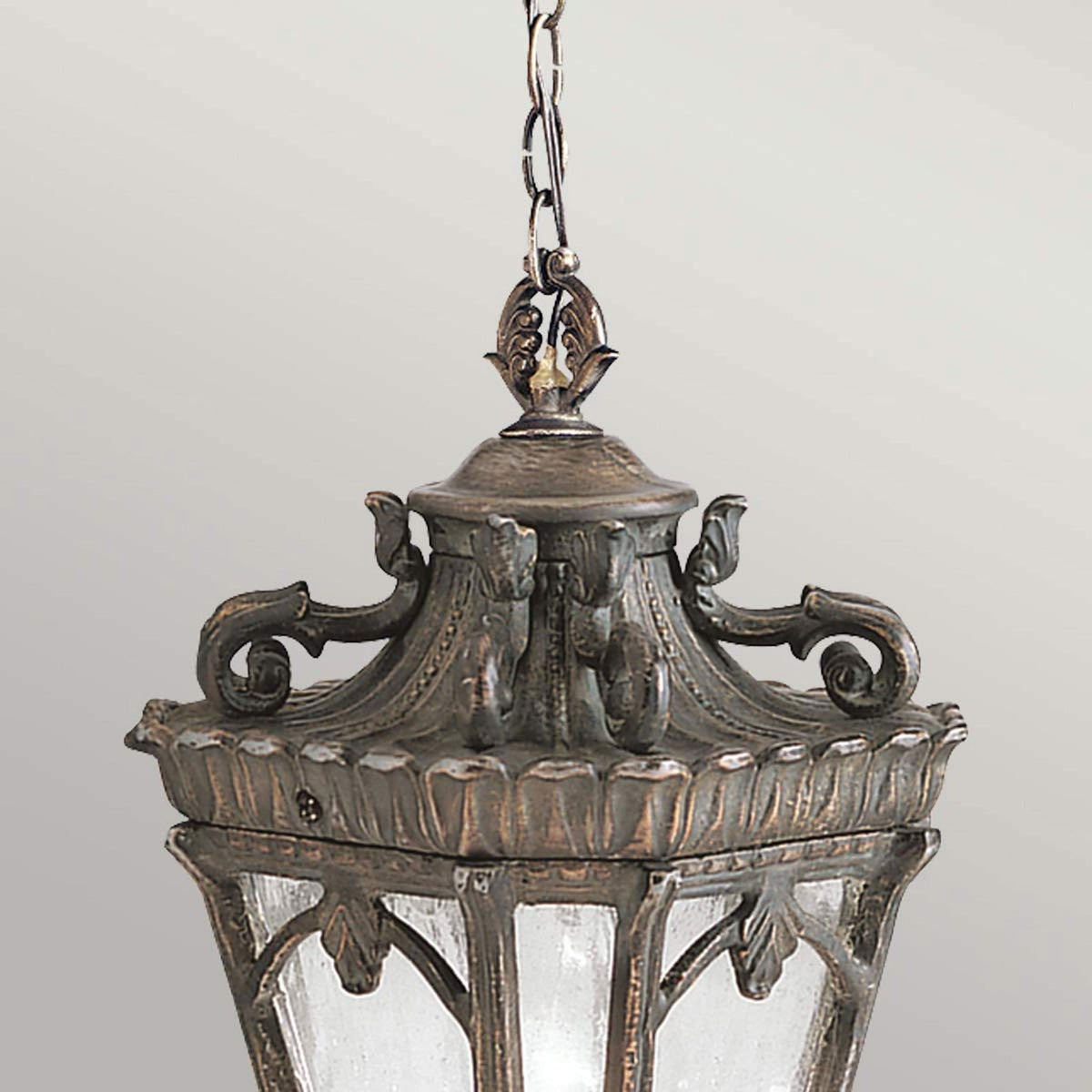 A close-up of a decorative bronze outdoor hanging lantern, highlighting its intricate details.