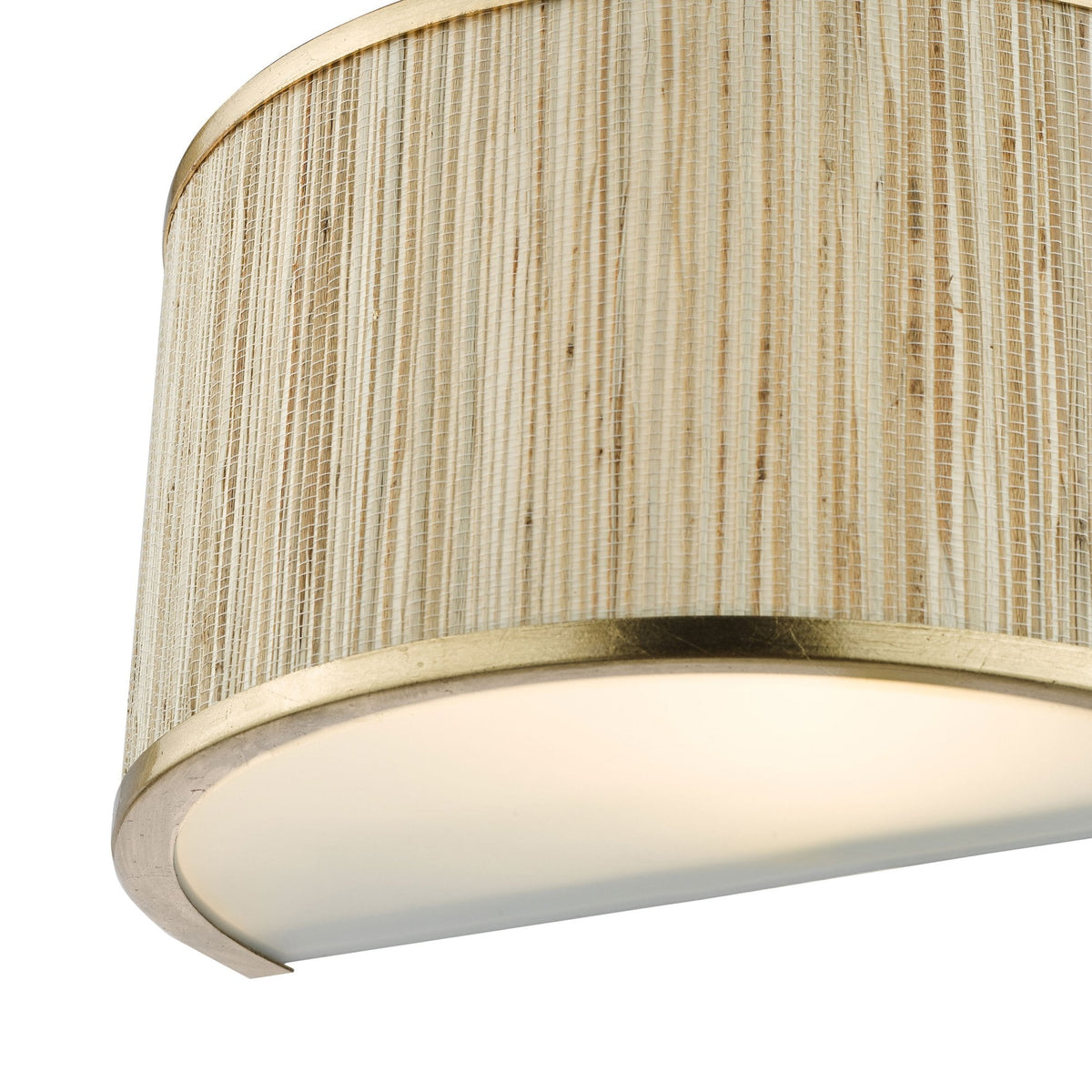 Close-up of a light fixture with a woven shade and a gold-colored trim, emitting a soft glow.