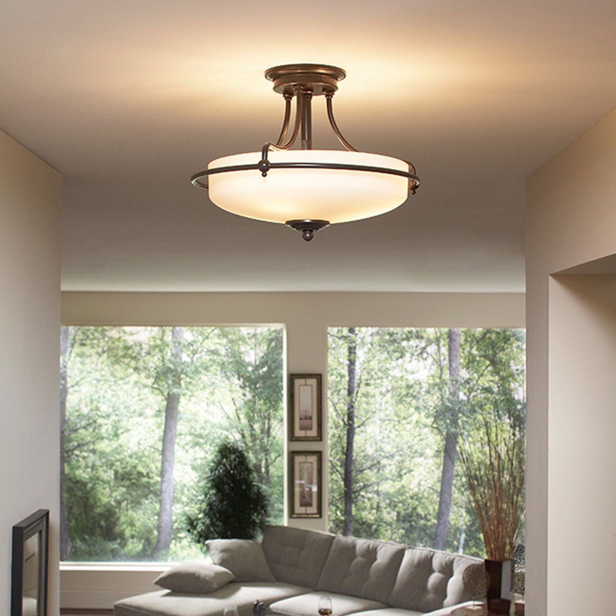 A semi-flush ceiling light illuminating a living room with large windows.