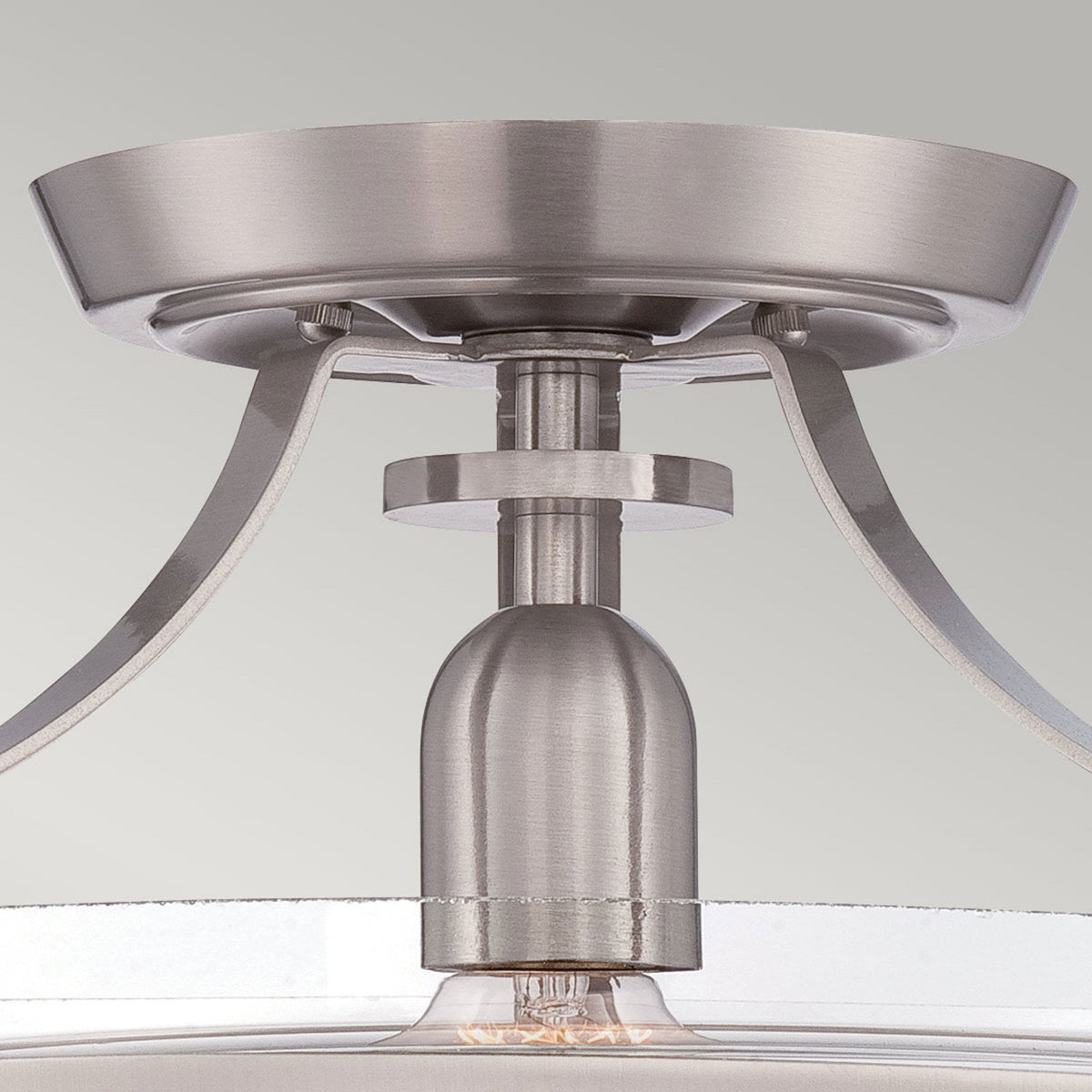 A detailed view of the brushed nickel base and mounting hardware of the ceiling light.