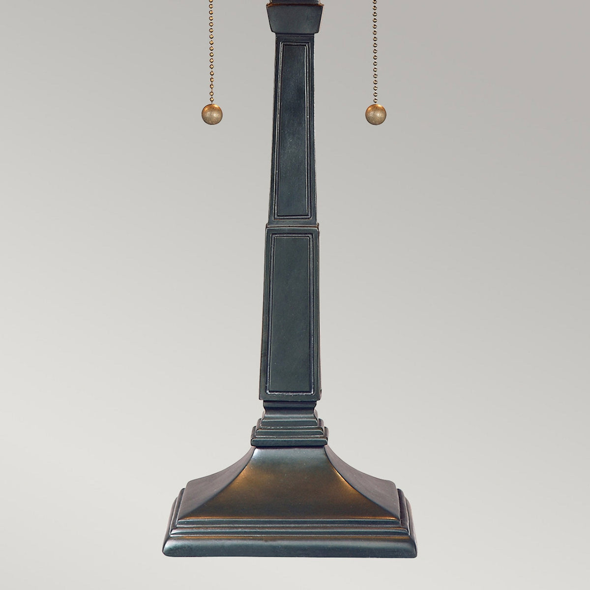 The base and lower stem of a vintage table lamp with a dark bronze finish.