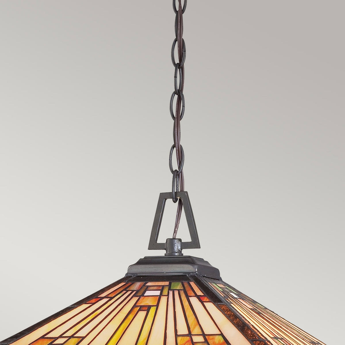 A close-up of the chain and upper section of a square Tiffany glass pendant light.